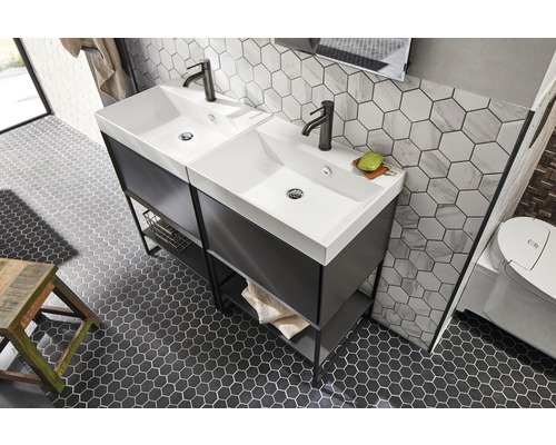 Badrum med dubbla handfat, underskåp, kranar och hexagonala plattor på vägg och golv