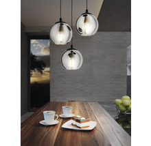 Scen med tre runda hängande glaslampor ovanför ett träbord