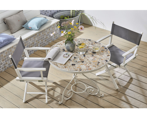 Trädgårdsscen med mosaikbord, regissörsstolar, blommor och drycker utomhus