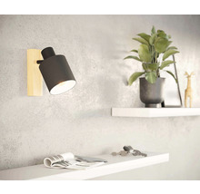 Vägglampa med träsockel och krukväxt på hylla