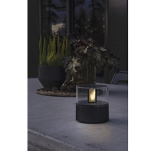 Dekorativ bordslampa i plast på ett bord utomhus.