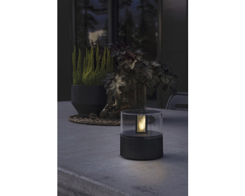 Dekorativ bordslampa i plast på ett bord utomhus.