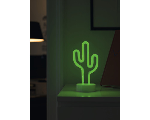 Dekorativ bordslampa i neon som ser ut som en kaktus på ett nattduksbord