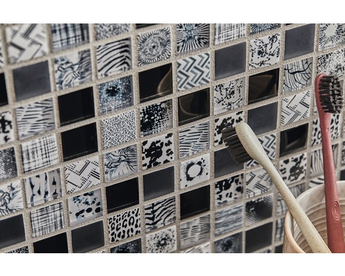 Detaljbild av mosaikplattor med olika mönster och två tandborstar