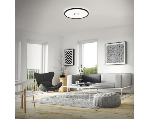 Vardagsrum med taklampa, soffa, fåtölj och dekorationer