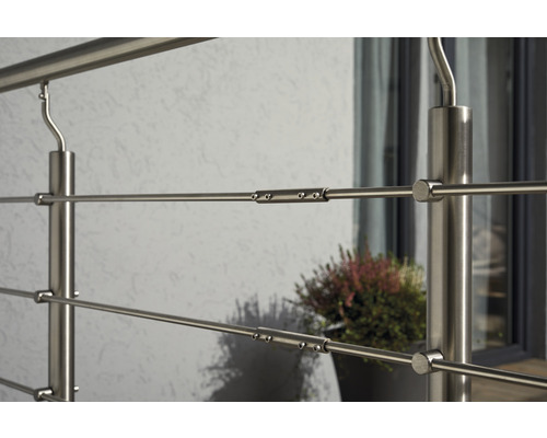 Detaljbild av ett rostfritt stålräcke med horisontella spjälor och stolpar