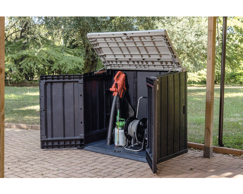 Öppet trädgårdsskåp med trädgårdsredskap utomhus