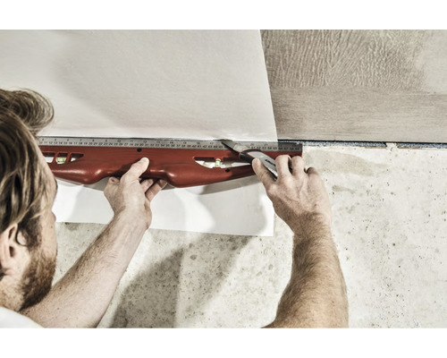 Skära tapeter med skärmaskin och vattenpass