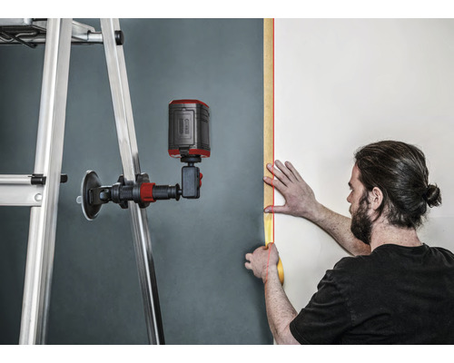 Användare med linjelaser som riktar in sig på en vägg med stege