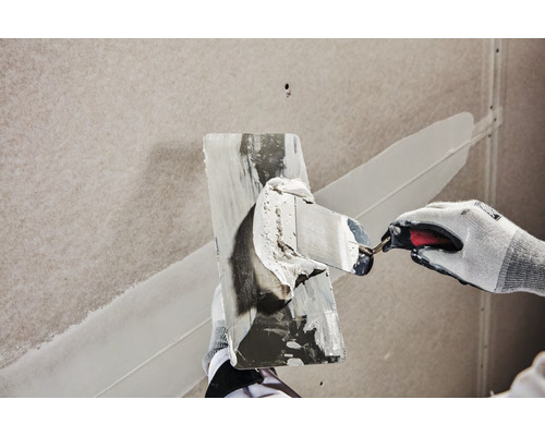 Hantverkare som jämnar ut spackel med en spackelspade