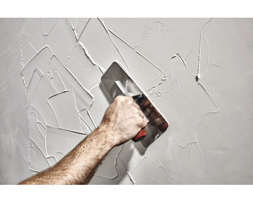 Applicering av gips på en vägg med en spackelspade