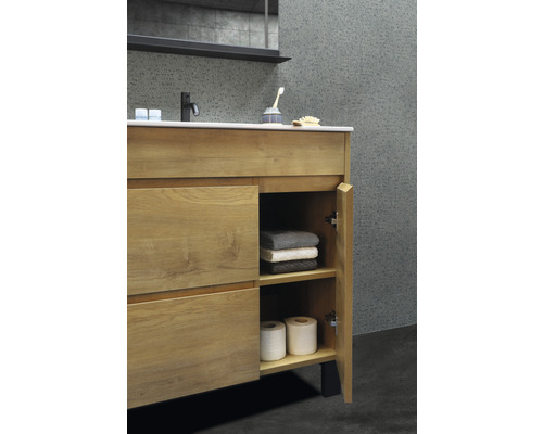 Tvättställsskåp med öppen dörr, handdukar och toalettpapper i badrummet