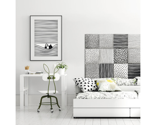 Inredning av ett rum med skrivbord, stol och säng i svartvitt.