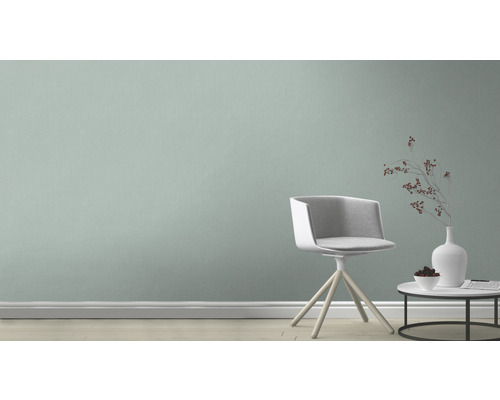 Miljö med stol, bord och dekorationer framför en vägg