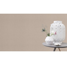 Dekorativ scen med en vit lykta, en vas med blommor och en liten dekoration på ett bord