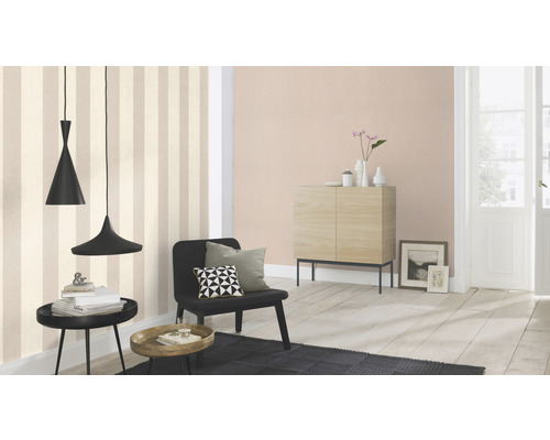 Vardagsrum med randig tapet, skänk, fåtölj och pendellampor