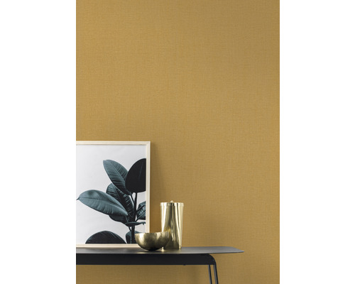 Närbild av en mönstrad tapet, kombinerat med en bild, en skål och en kanna på ett bord