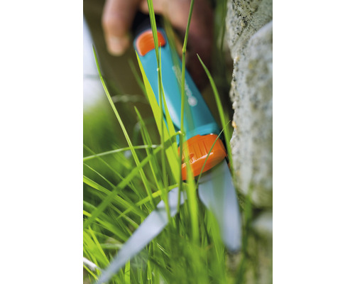 Gardena grässax klipper gräs vid en mur
