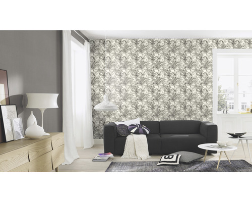 Ljust vardagsrum med soffa, byrå och blommigt mönstrad tapet