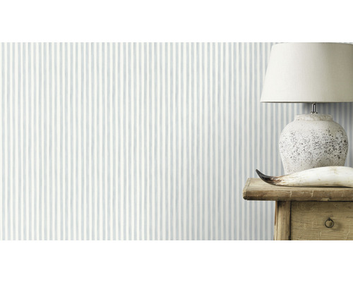 Tapet med randigt mönster i rummet, med en lampa på ett träbord