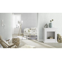 Ljust vardagsrum med randig tapet, soffa, öppen spis och trägolv för en mysig atmosfär