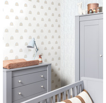 Ett barnrum med en skötbyrå, en garderob och en vägg med ett regnbågsmönster.