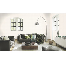 Vardagsrum med lädersoffor, träbord och diskret mönstrad tapet.