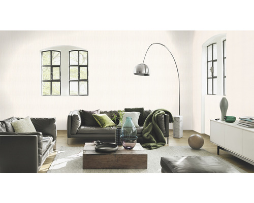 Vardagsrum med lädersoffor, träbord och diskret mönstrad tapet.