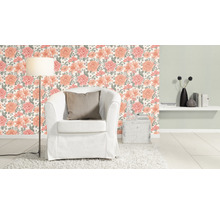 Vardagsrum med blommig tapet, fåtölj, golvlampa och dekoration