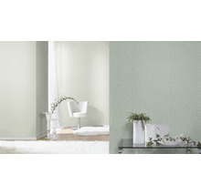 Ljust, vänligt rum med strukturtapeter och dekorativa element.