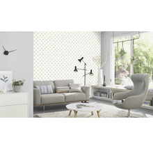 Vardagsrum med soffa, fåtölj och tapet med prickigt mönster