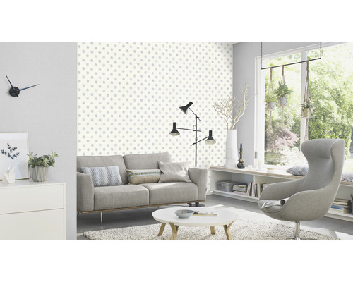Vardagsrum med soffa, fåtölj och tapet med prickigt mönster