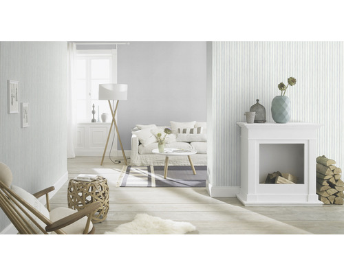 Ljust vardagsrum med randig tapet, öppen spis och möbler