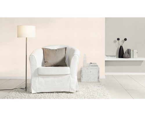 Ljust rum med fåtölj, golvlampa och hylla