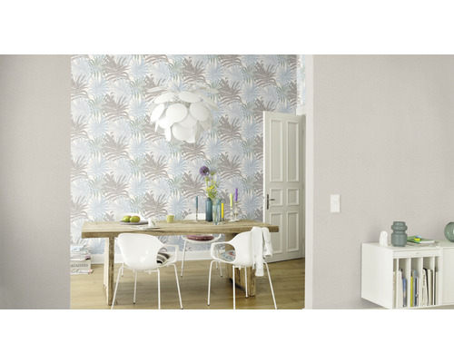 Matsal med matbord, stolar och mönstrad tapet med växtmotiv