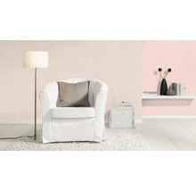 Dekorativt vardagsrum med fåtölj, golvlampa, hylla och mönstrad tapet