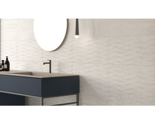 Modernt badrum med handfat, spegel och väggplattor med vågmönster.