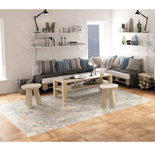 Ljust vardagsrum med möbler av pallar, mönstrad matta och vägghyllor.