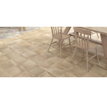 Lagt golv av kvadratiska plattor i en interiör med matbord och stolar.