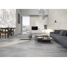 Ljust vardagsrum med grå golvplattor, soffa och träbord