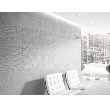 Väggdekoration med gråa plattor och två vita stolar