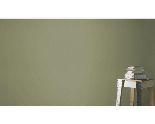 Vägg med färgskikt och stapel böcker på en pall