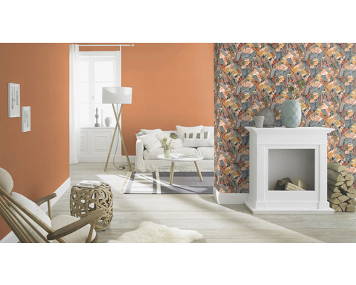 Vardagsrum med vita möbler, mönstrad tapet och orange vägg