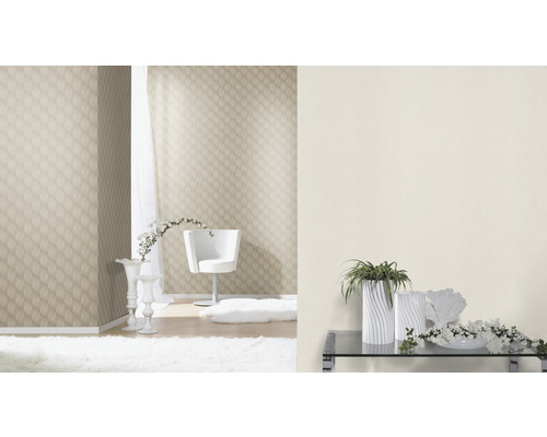 Ljust rum med mönstrad tapet, vit fåtölj och blomsterdekorationer