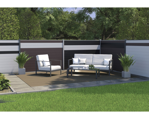 Trädgårdsscen med staket, loungemöbler och växter