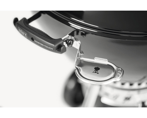 Detaljvy av Weber Master-Touch grill med lockhållare och handtag