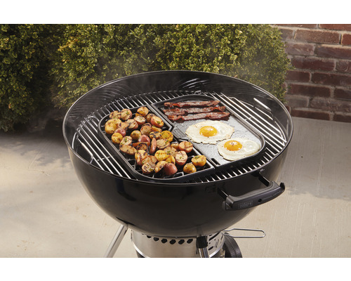 Weber grill med frukostingredienser som potatis, bacon och stekta ägg.