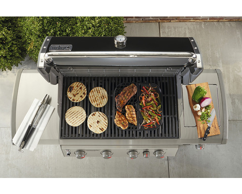 Grill med grillad mat, grilltång, skärbräda och ingredienser uppifrån