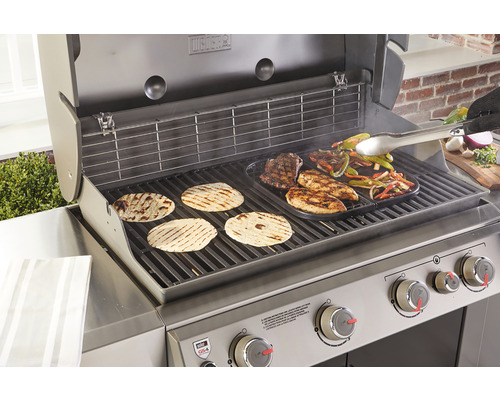 Weber grill med grillad mat och grilltång