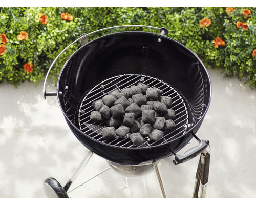 Kolgrill med grillbriketter på grillgallret.